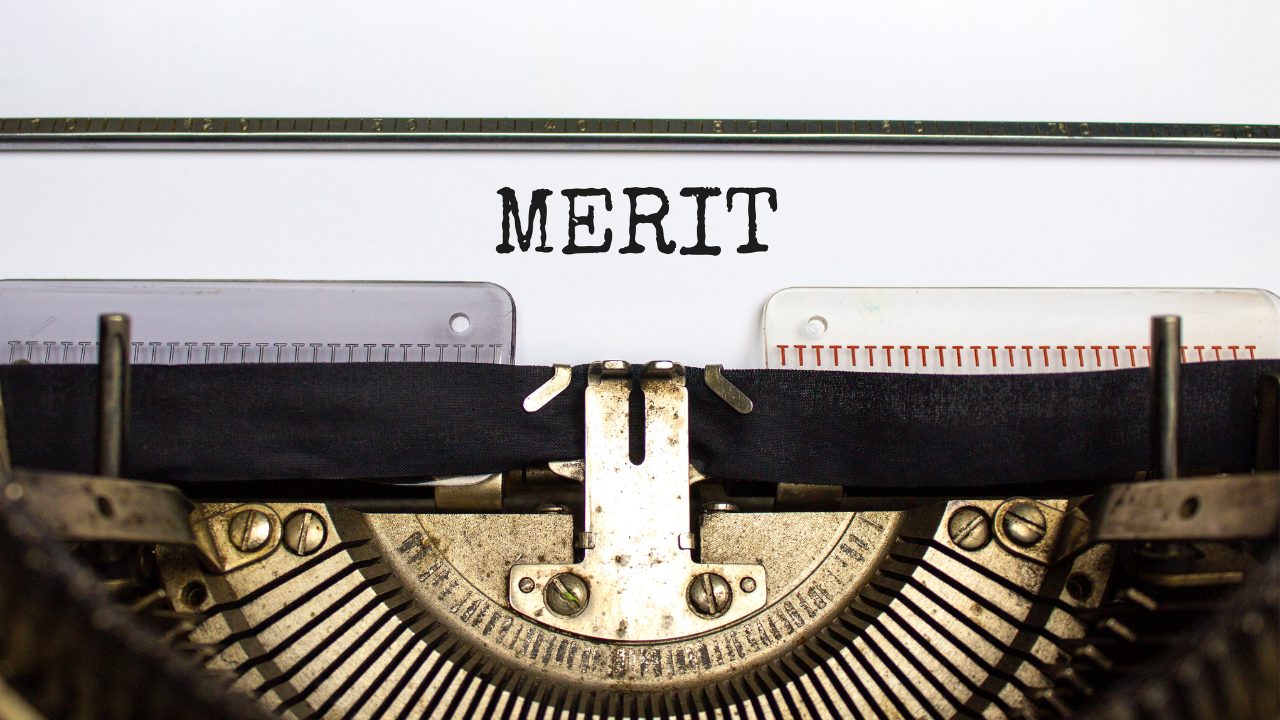 タイプライターで「MERIT」と打っている画像