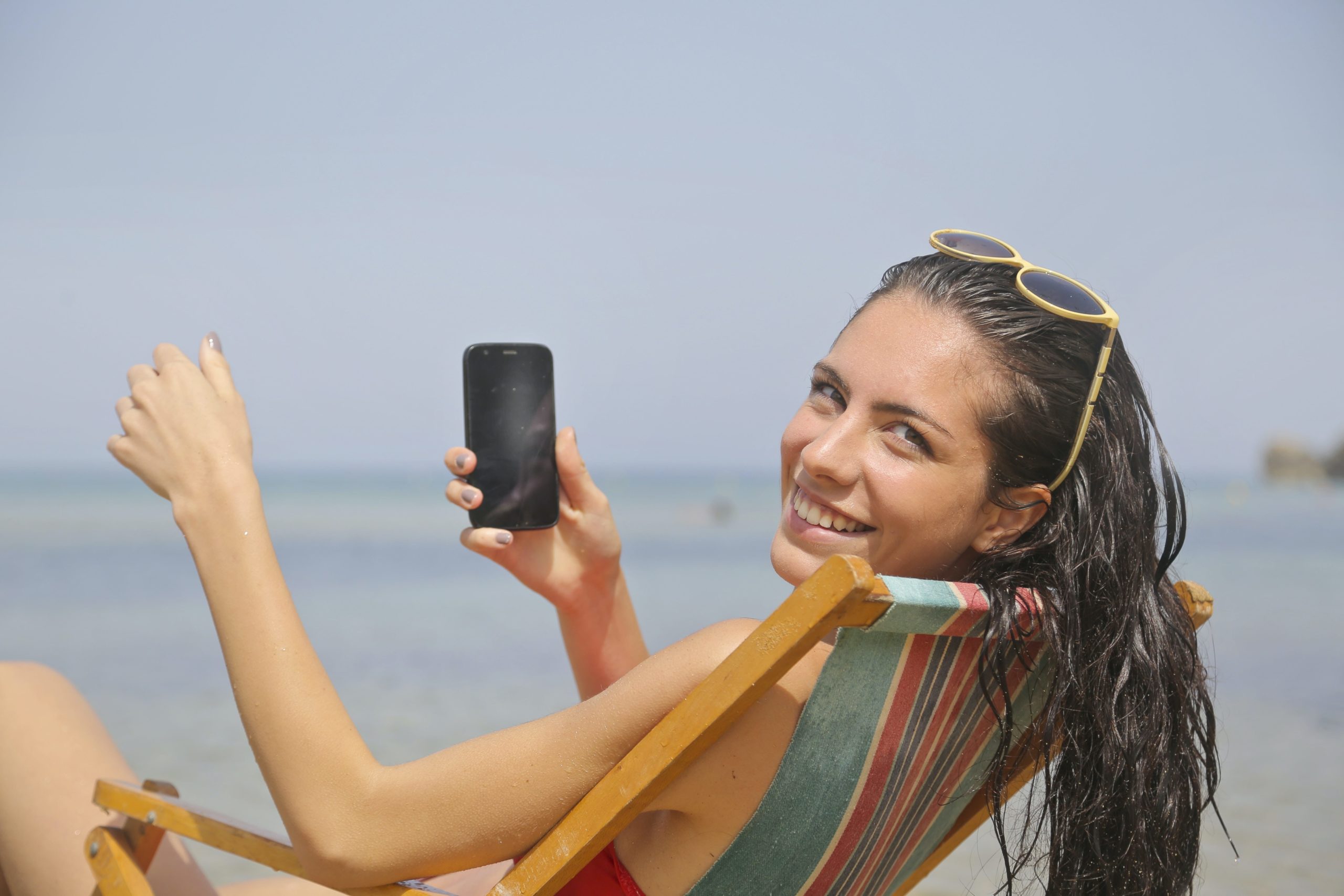 海辺とスマホと女性